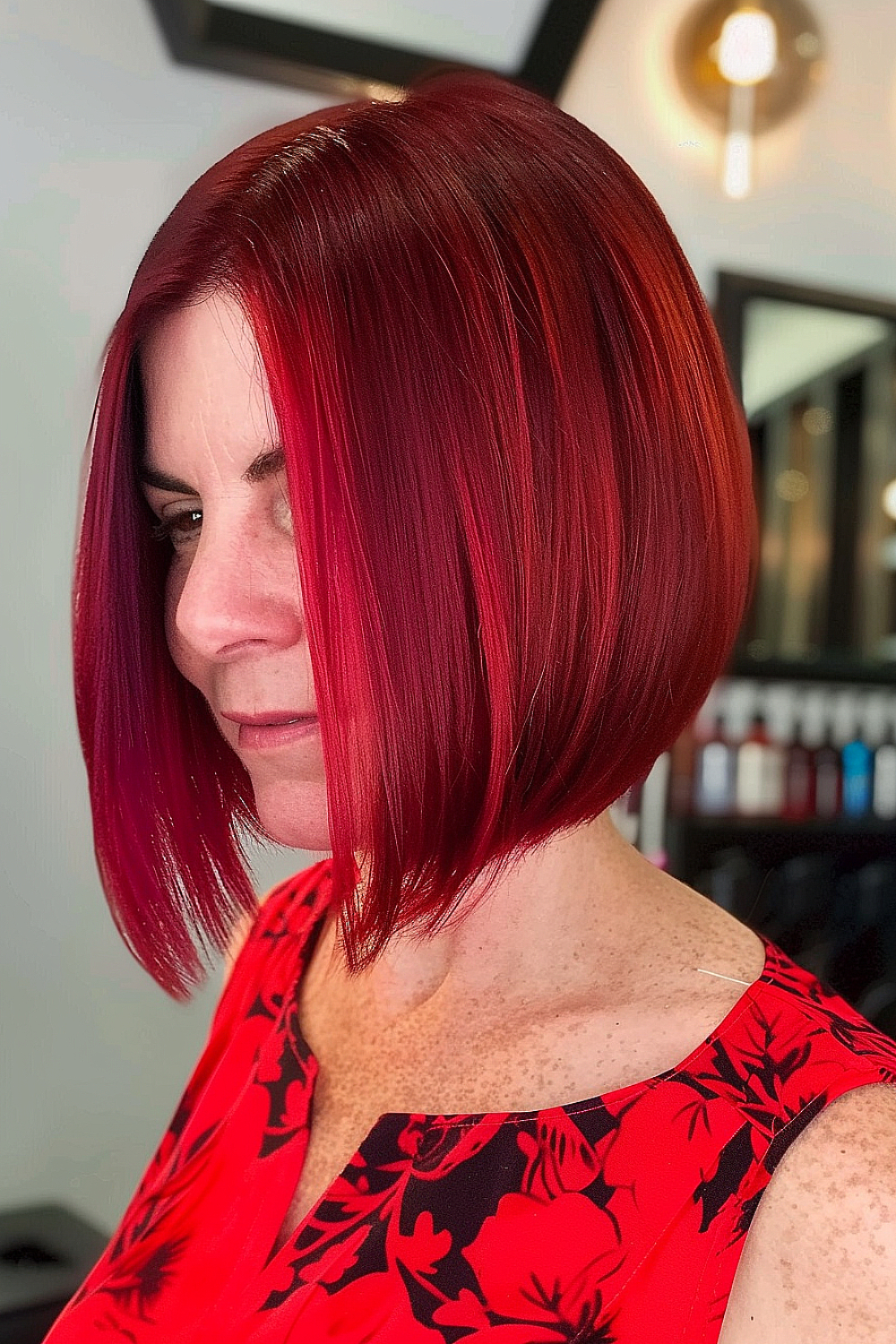 A woman with an angled bob, featuring deep and vibrant red tones