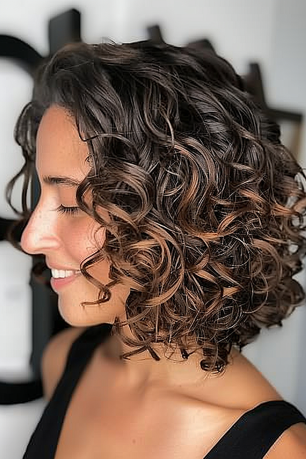 Woman with an angled curly lob and ombre coloring