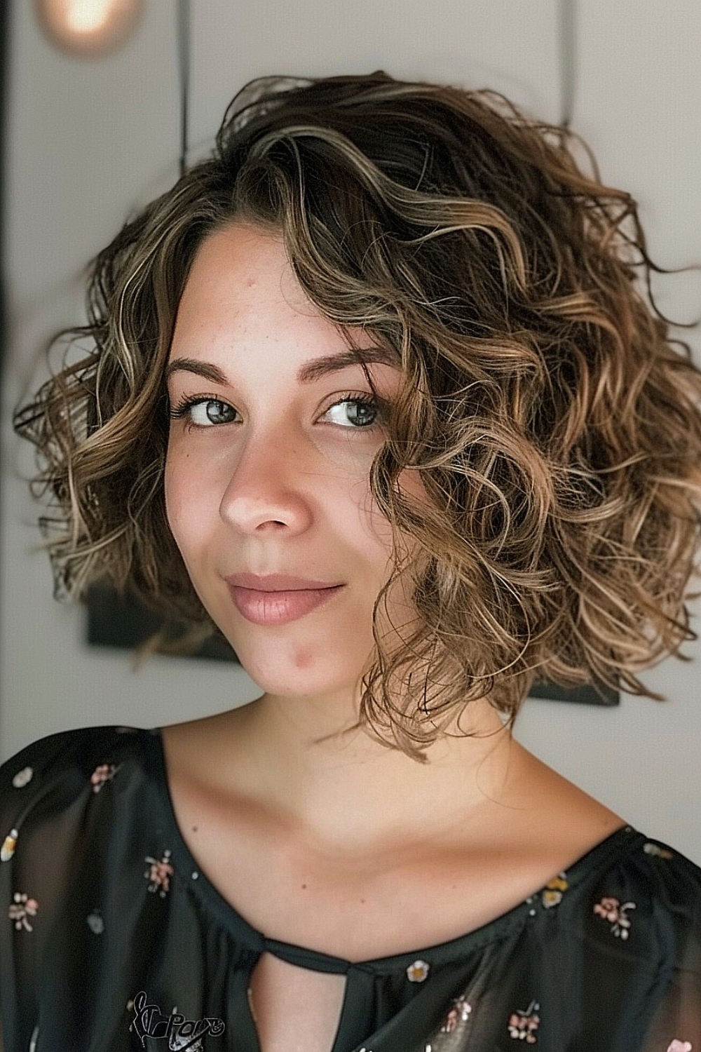 Asymmetrical curly bob with sun-kissed highlights