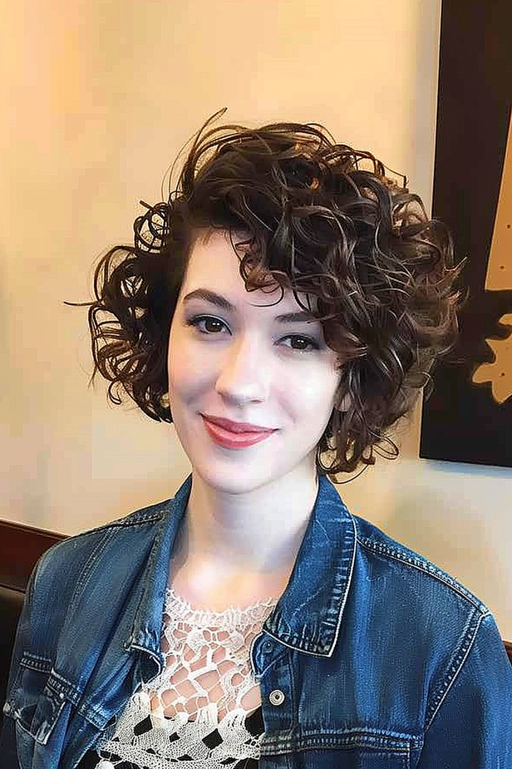 Woman with asymmetrical curly bob and side bangs