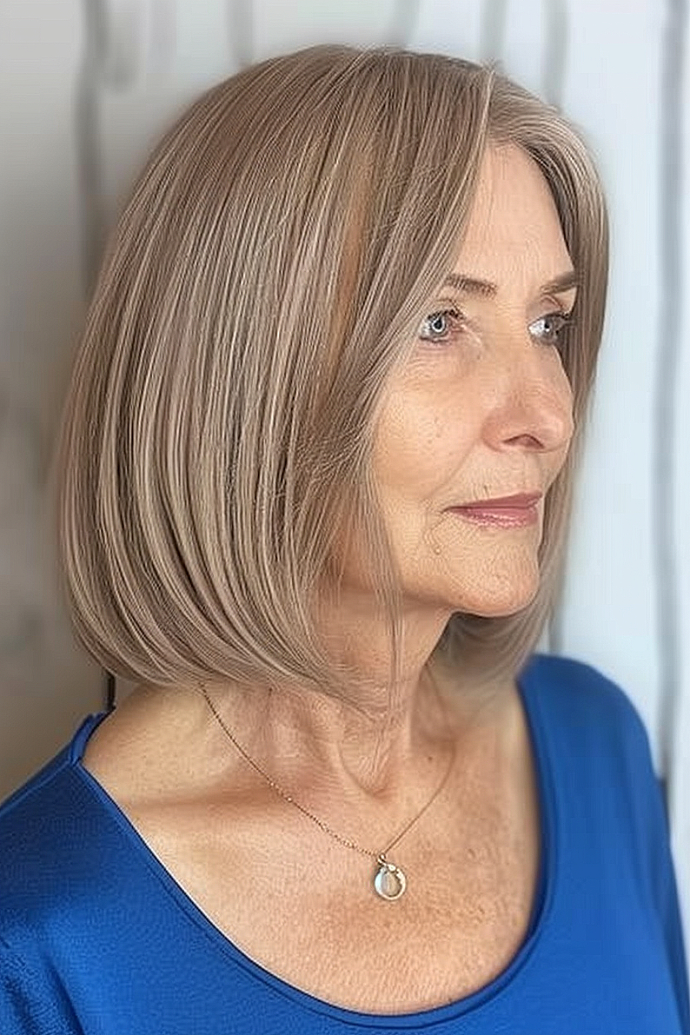 Woman with a sleek blunt cut bob in a cool taupe hue