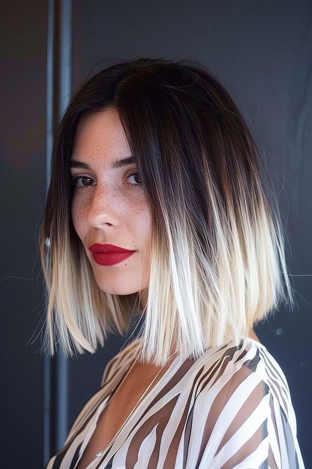 Blunt lob with ombre ends transitioning from dark roots to platinum blonde