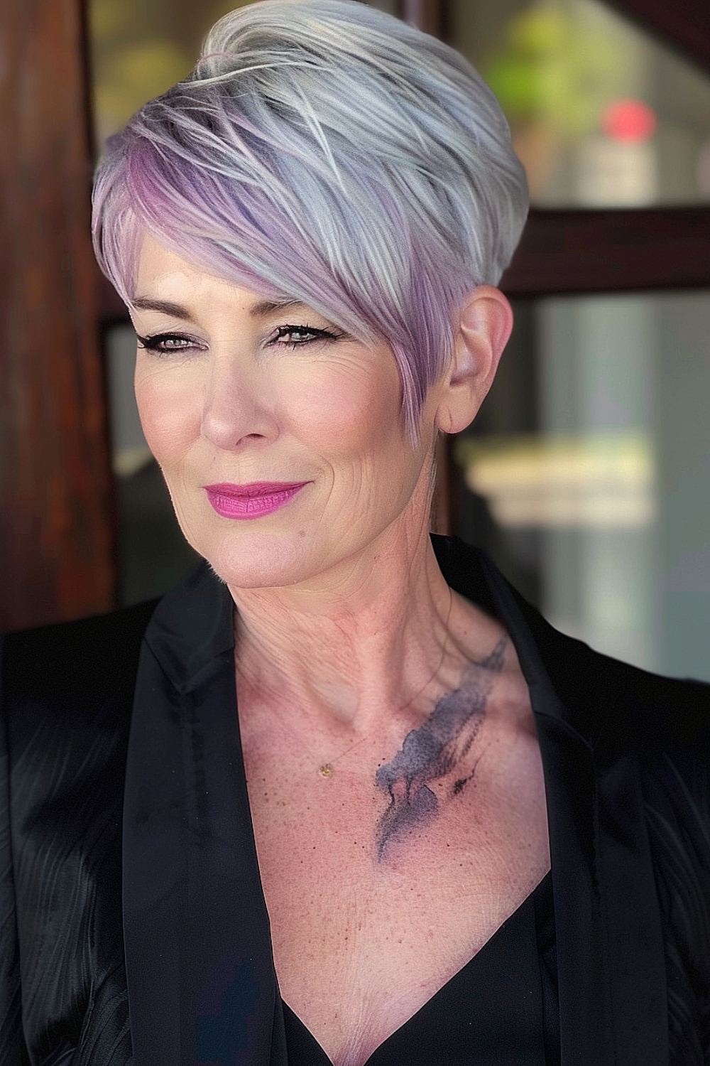 Woman with a bold pixie haircut featuring a deep side part and lavender highlights