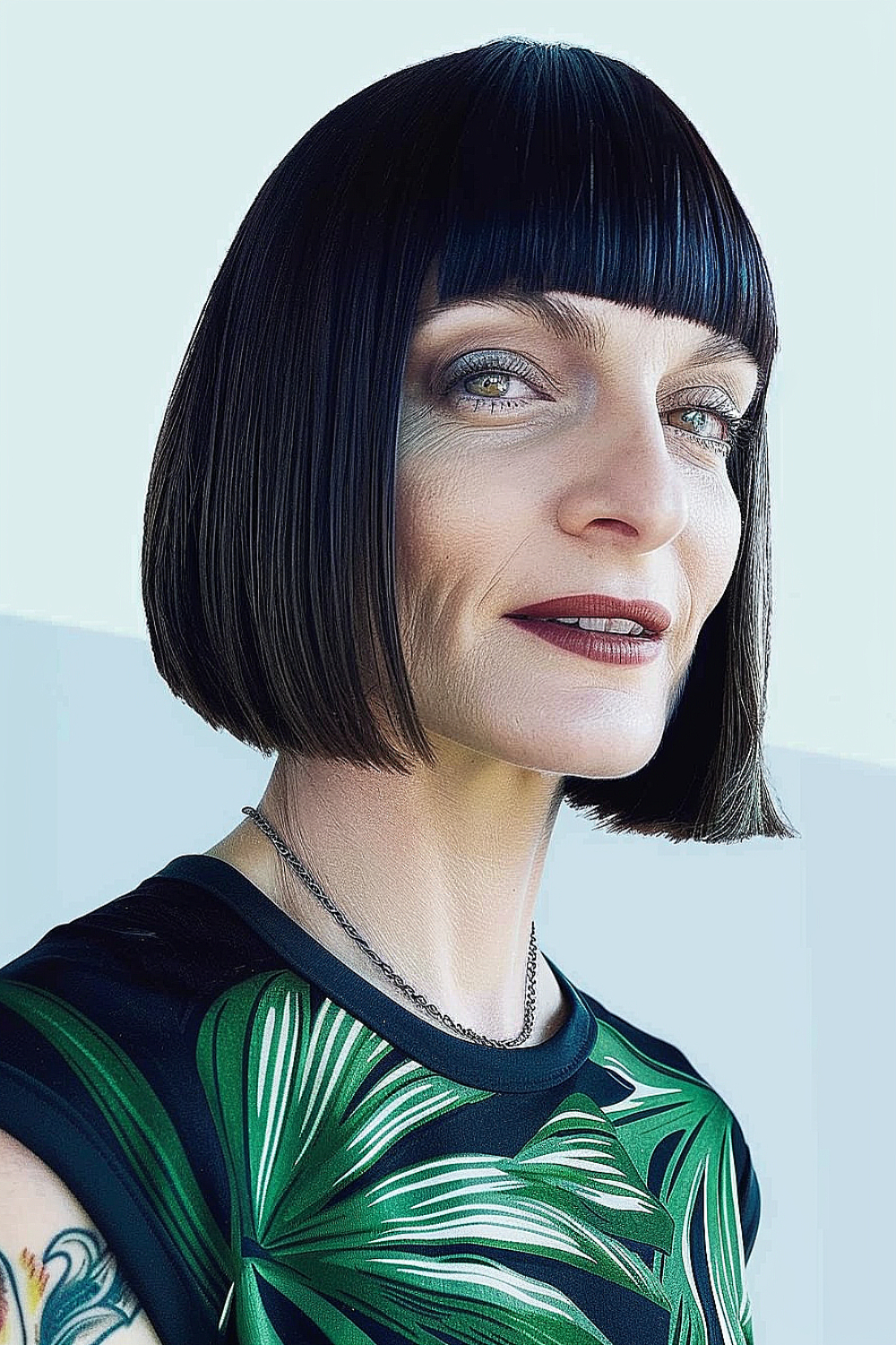 Woman with a sleek, black boxed bob and ultra-defined straight bangs