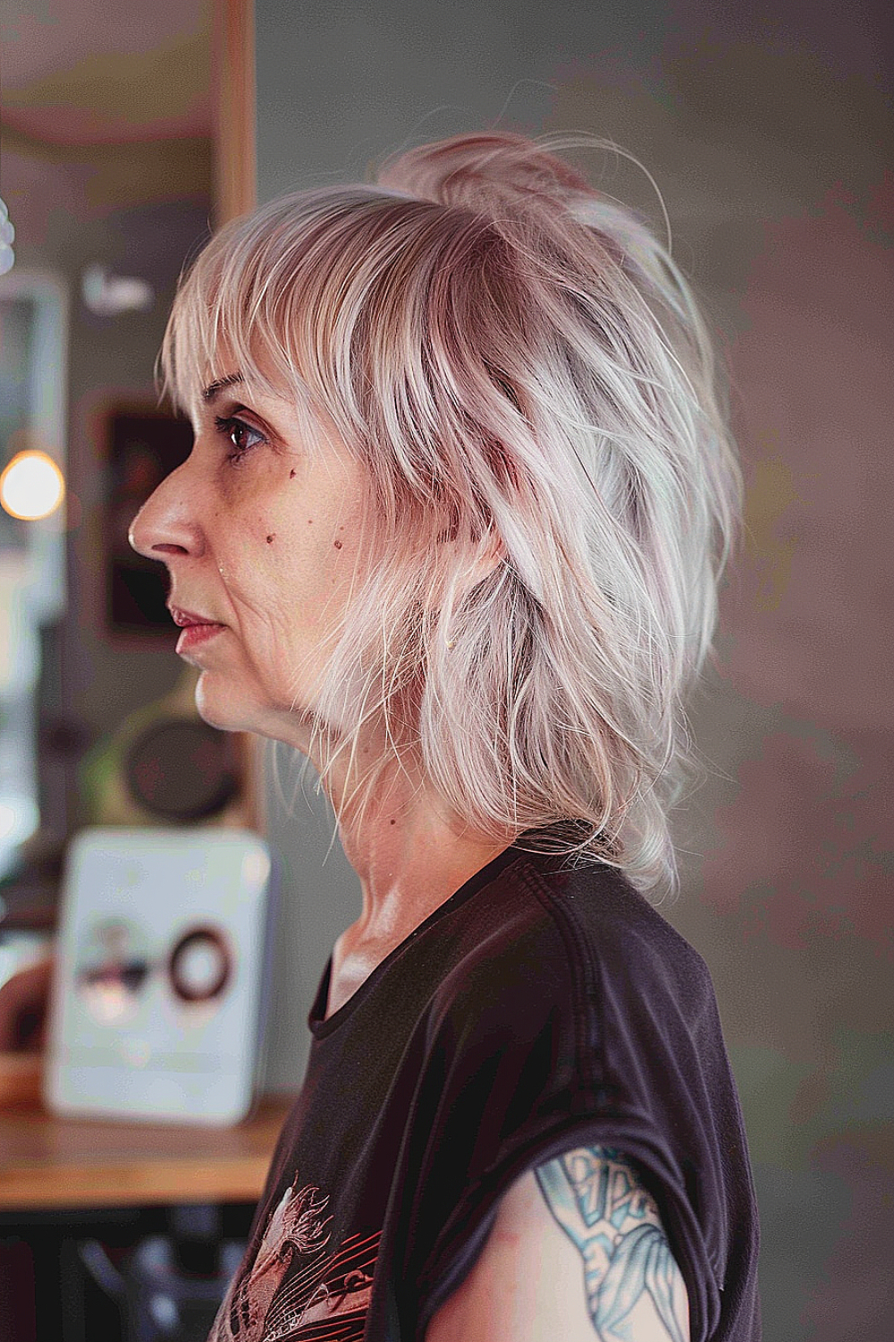 A woman with a choppy mullet in silvery blonde, exuding a modern rocker chic style