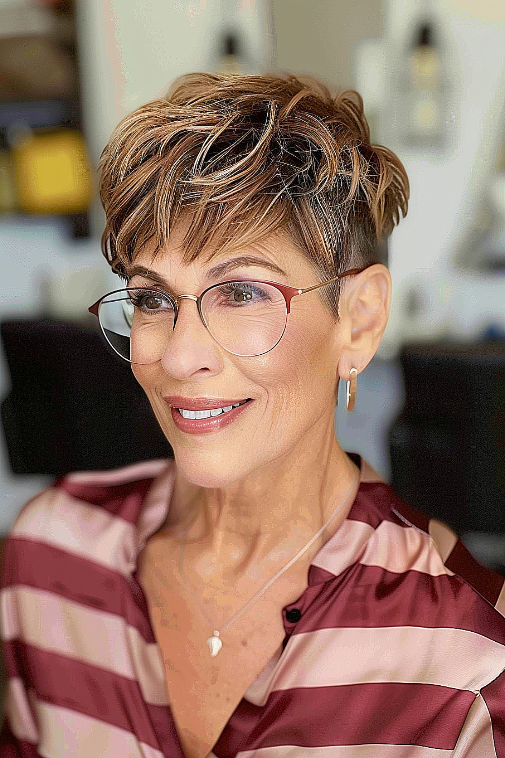 Choppy pixie haircut with soft highlights on a woman over 50