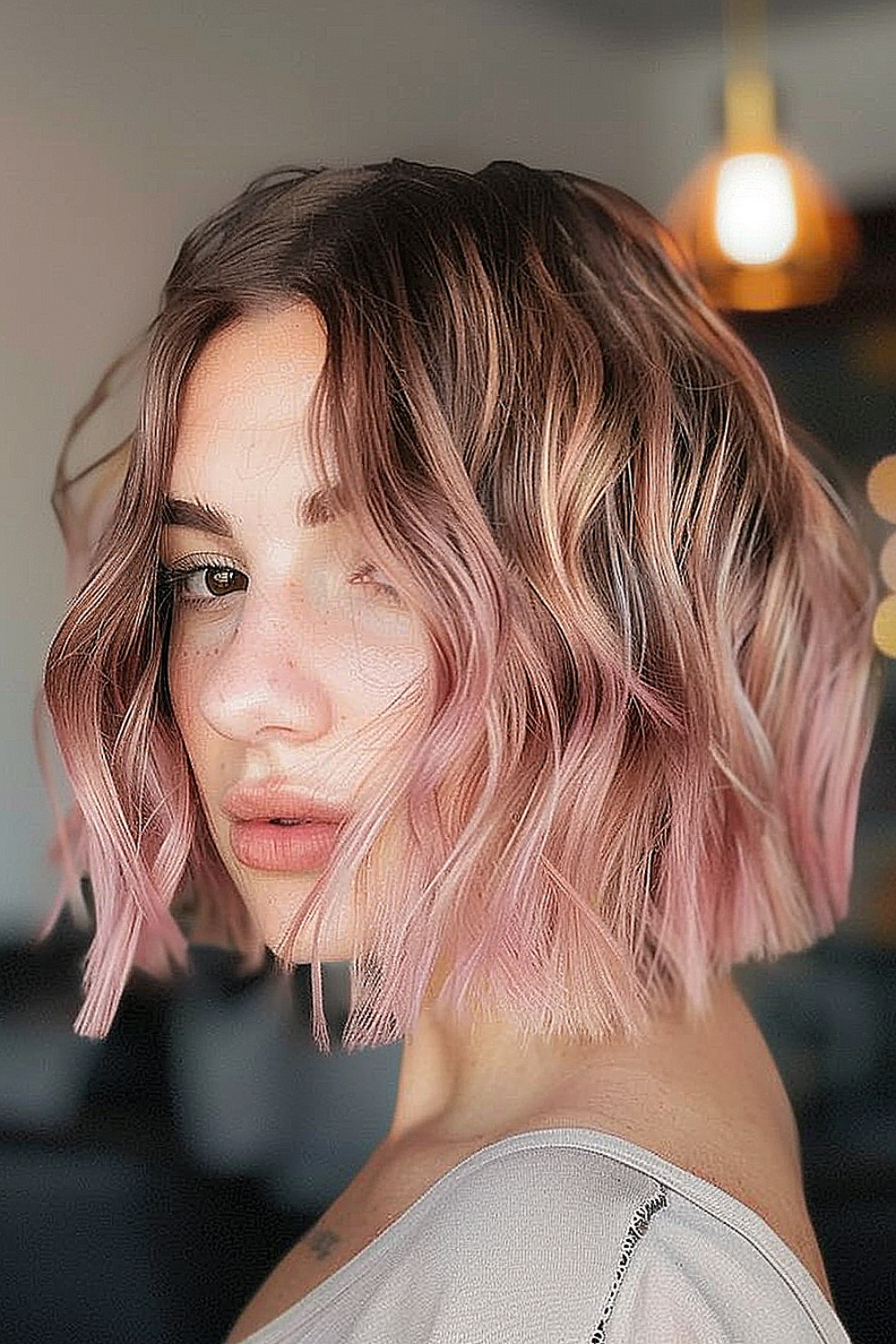 Woman with a choppy textured bob and rose gold highlights