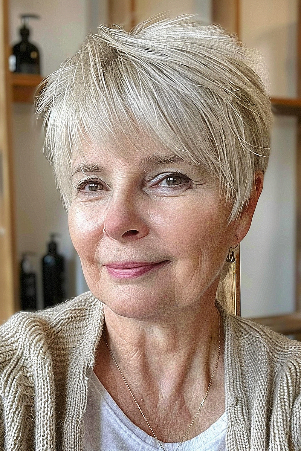 A mature woman with a classic pixie cut and feathered bangs