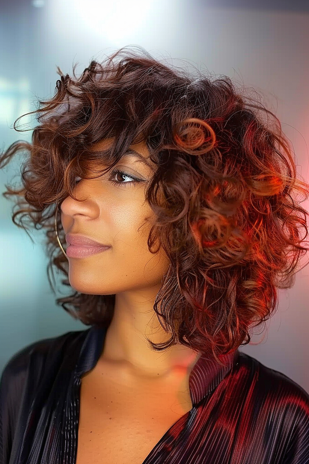 Woman with curly angled lob and swoopy bangs