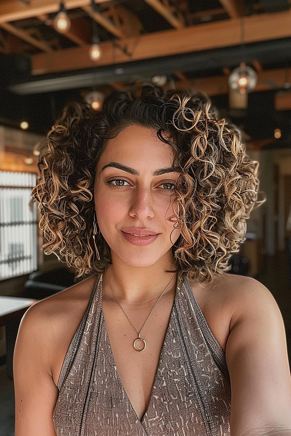 Woman with a curly bob hairstyle featuring balayage highlights