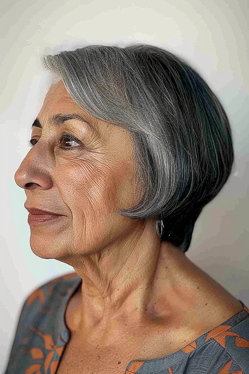 Woman with an ear-length layered bob and side-swept bangs