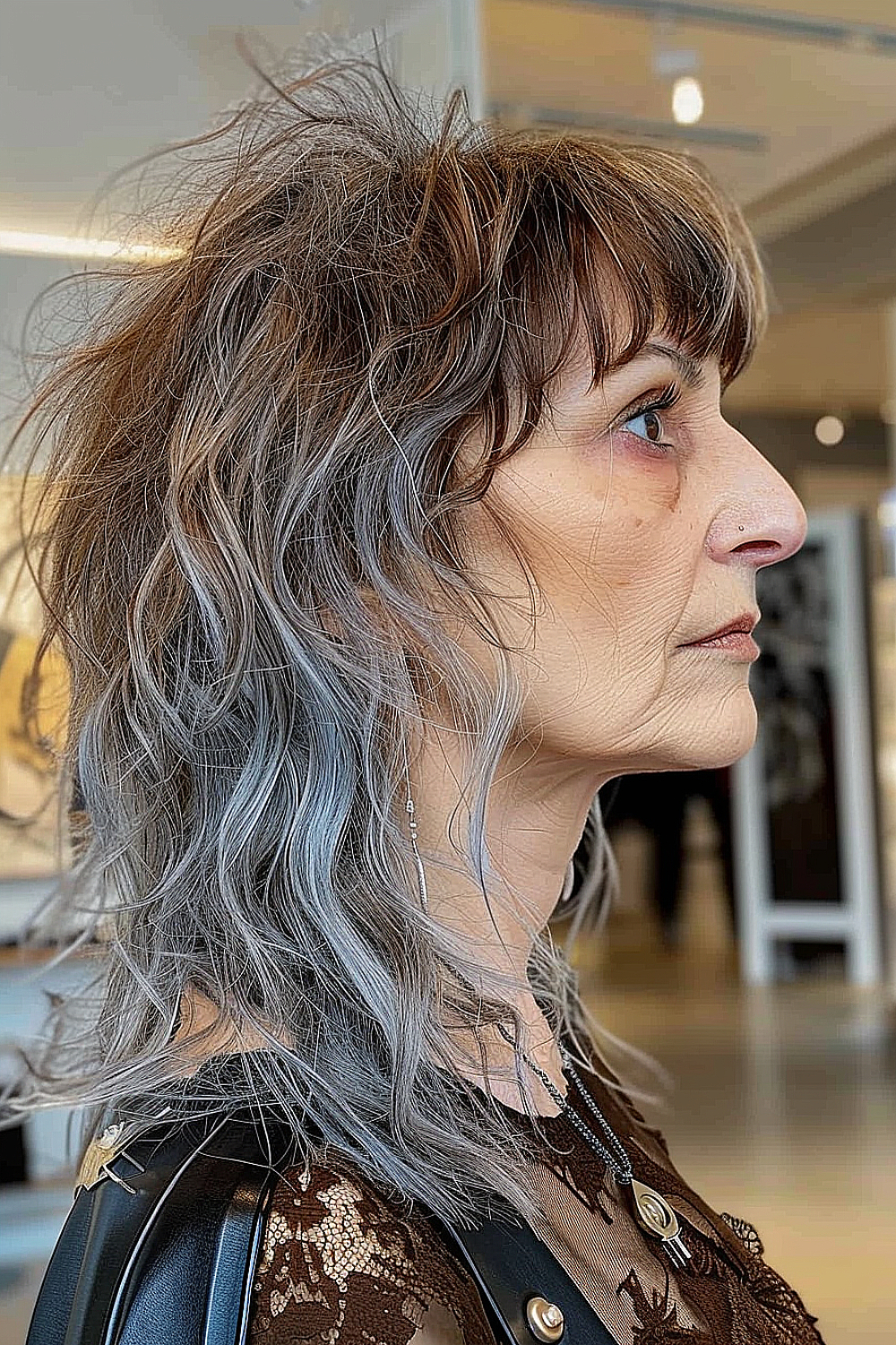 An edgy mullet shag with choppy layers and silver-ash balayage for women over 50