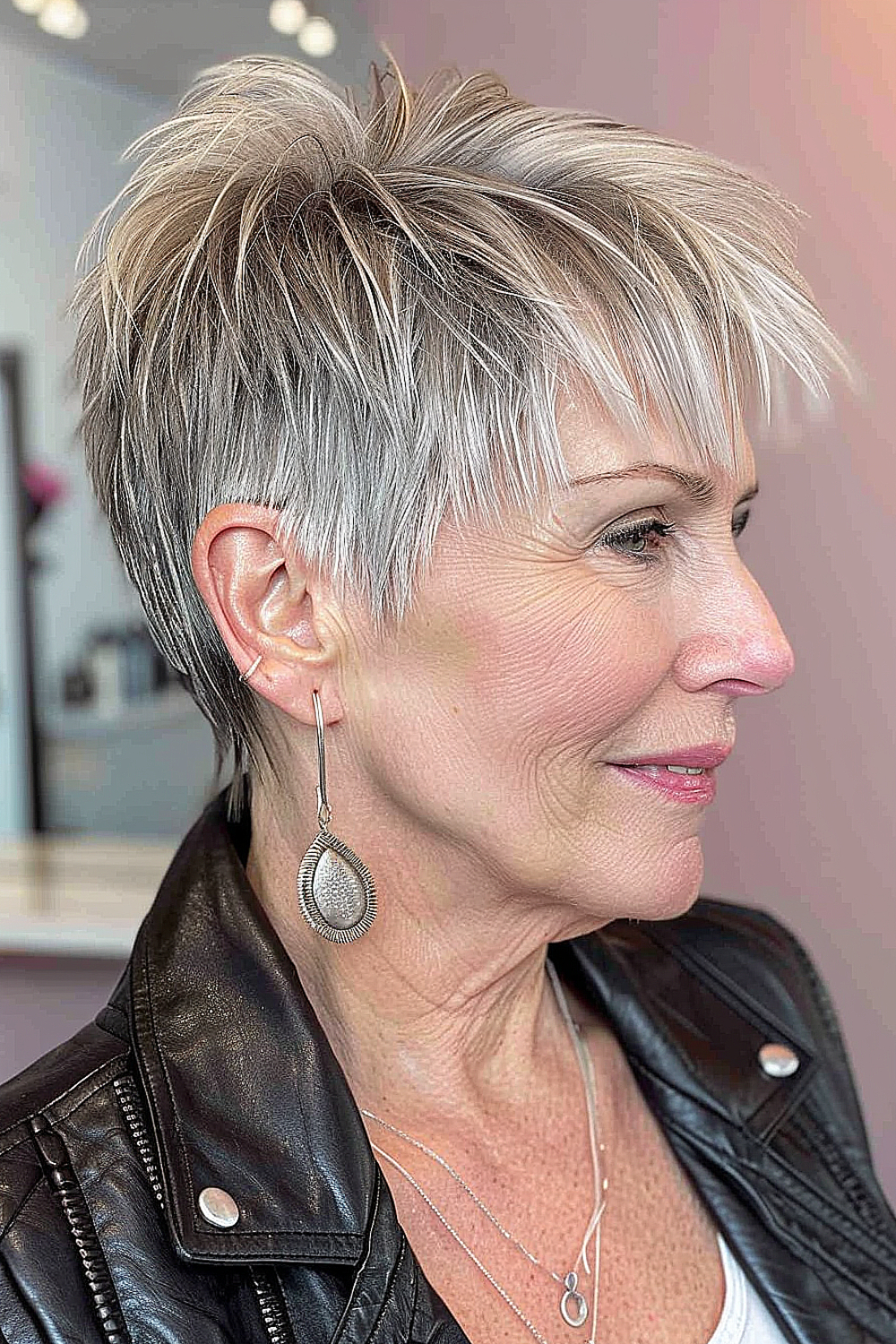 Edgy pixie with razor cut sides and silver hair on a woman over 50