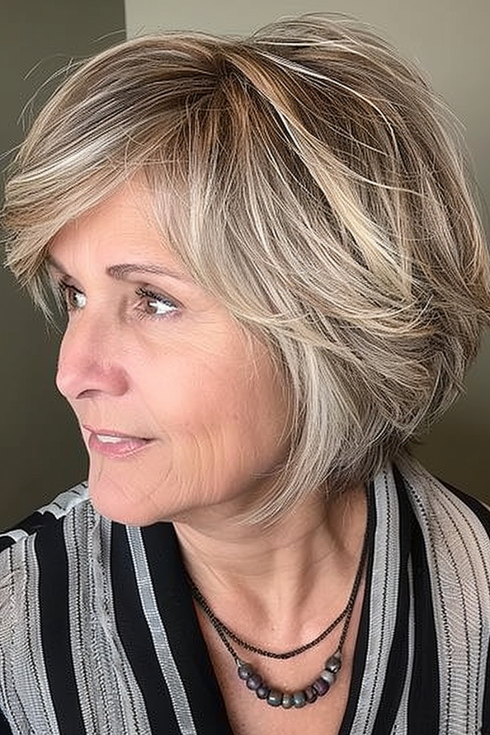 Woman with a dynamic jaw-length shaggy bob with honey blonde highlights