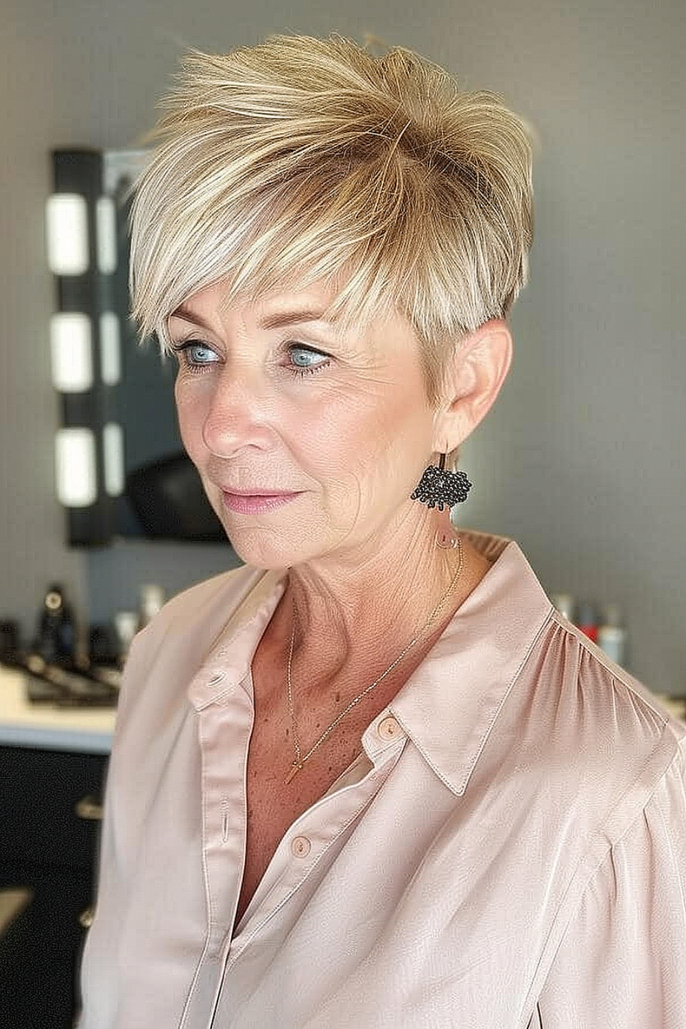 Woman with a layered golden blonde pixie cut, enhancing a vibrant and youthful appearance