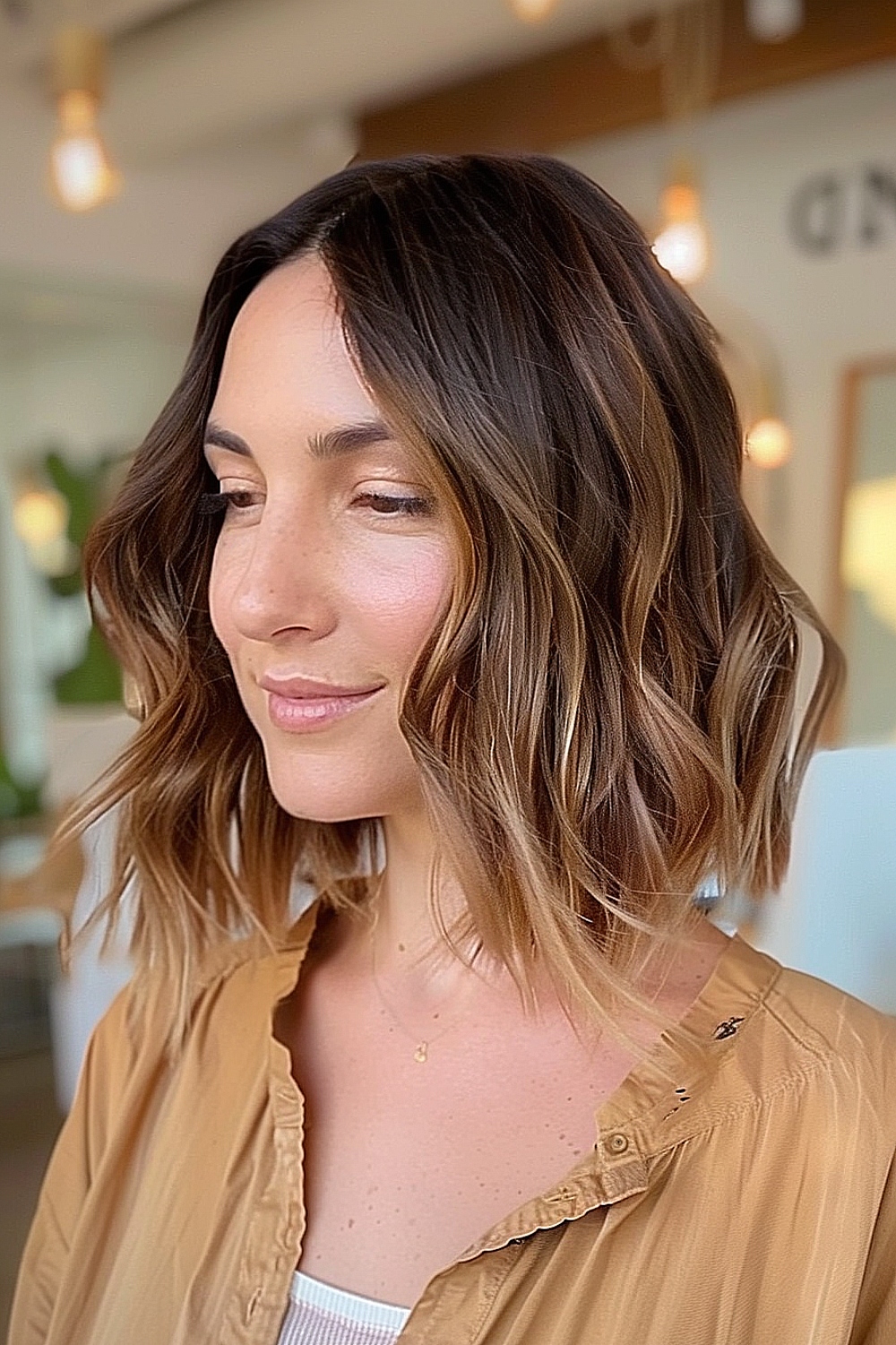 Woman with a layered wavy bob and sombre highlights