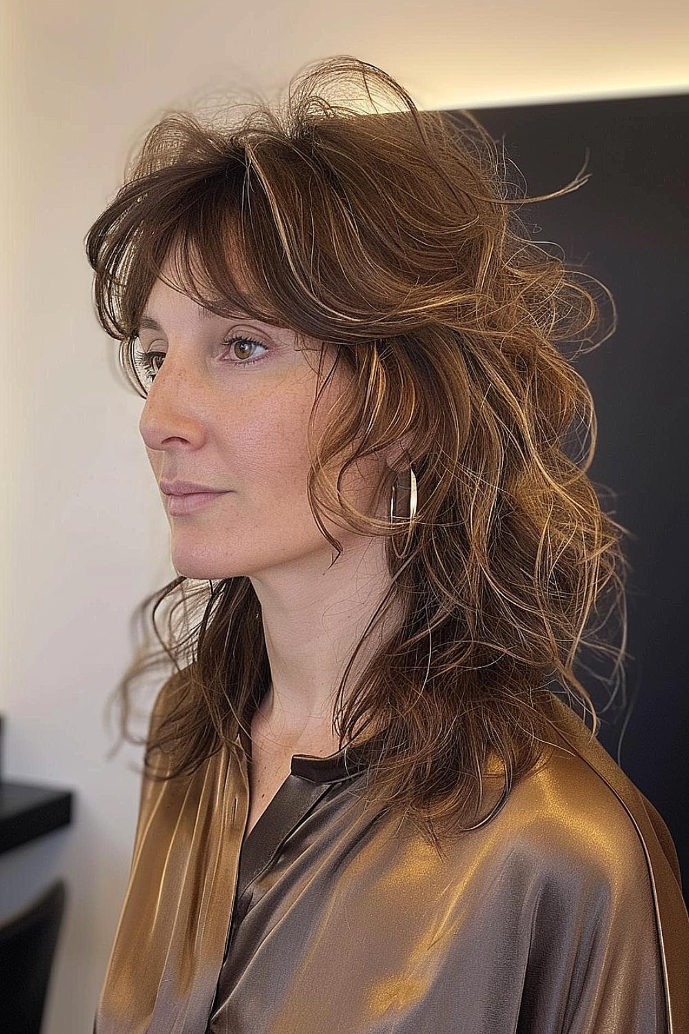 Woman with a modern mullet shag haircut featuring feathered layers and subtle highlights