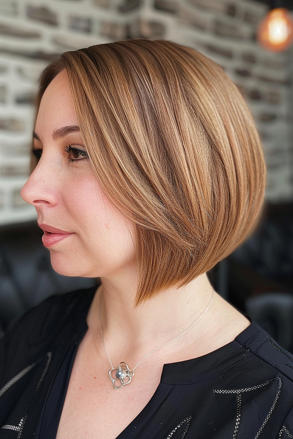 Side view of a woman with a neat layered bob haircut featuring precision ends