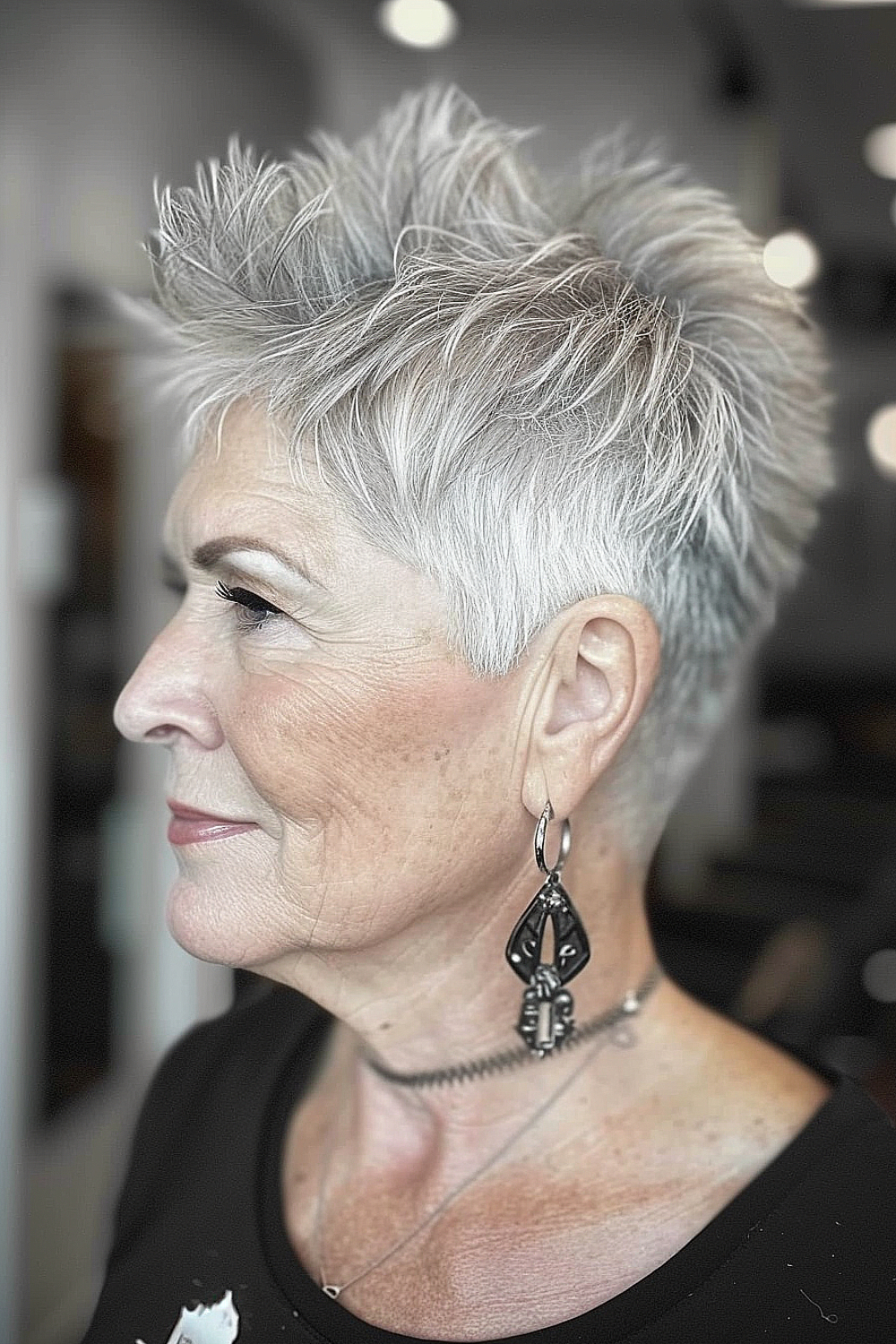 A woman with a silver pixie haircut featuring a spiky top for an edgy, playful look