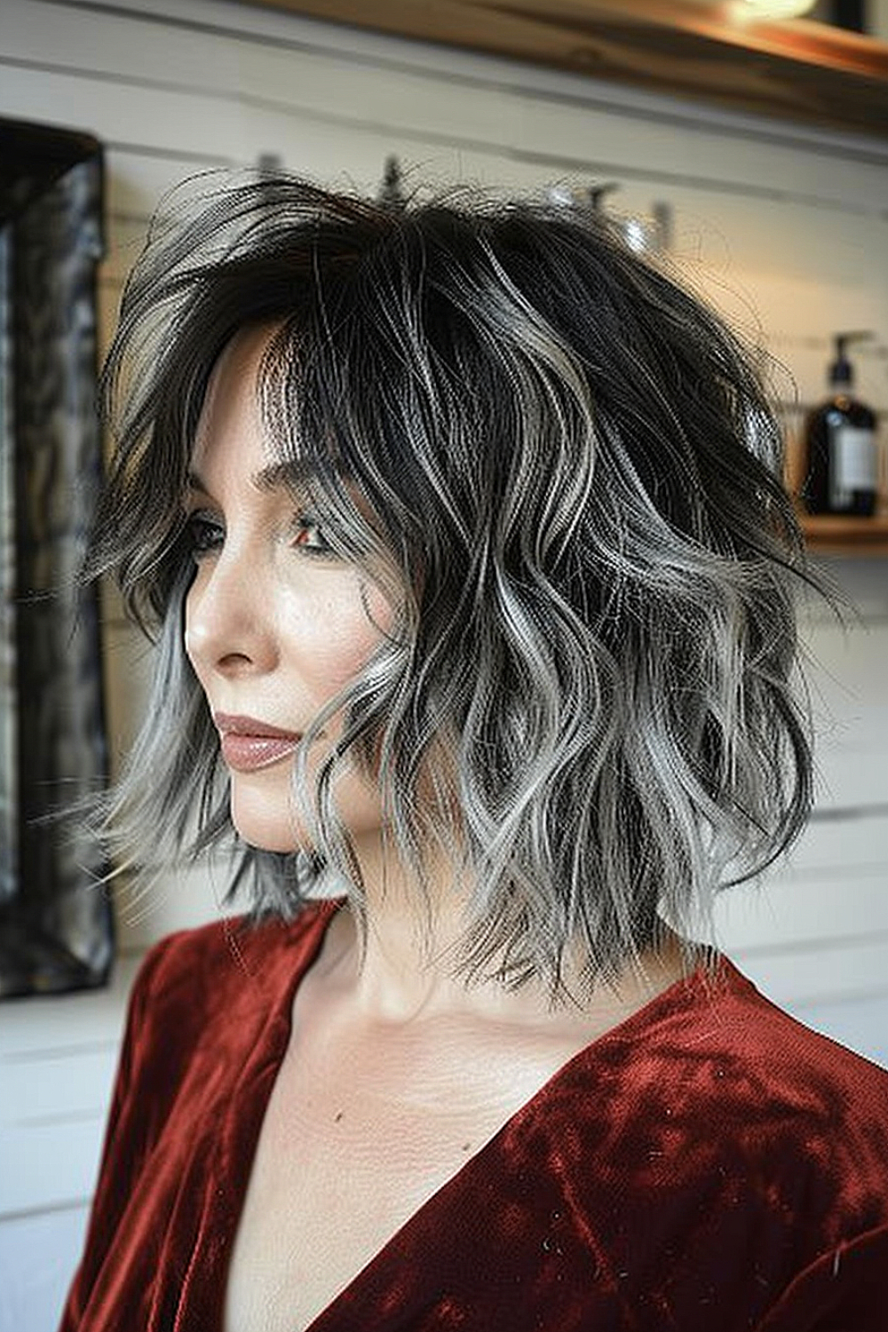 Mature woman with a shaggy bob highlighted with silver streaks, combining dark and light tones