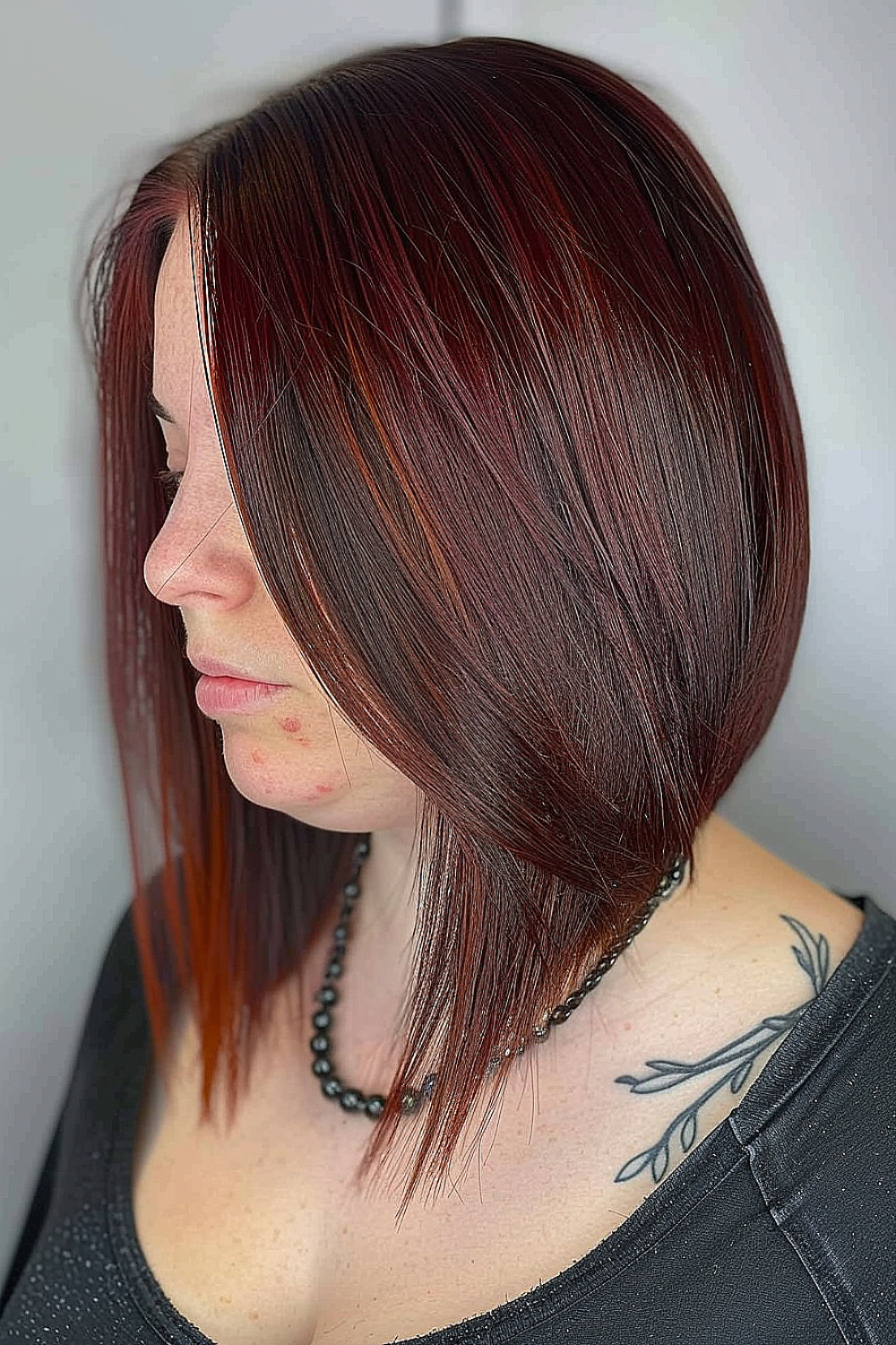 A sleek angled lob with a luxurious deep burgundy color, exuding sophistication and boldness