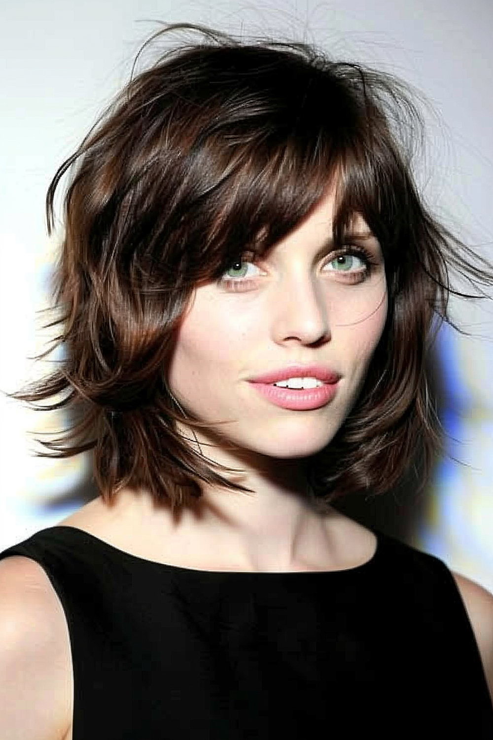 Woman with a sleek shag haircut and side-swept bangs