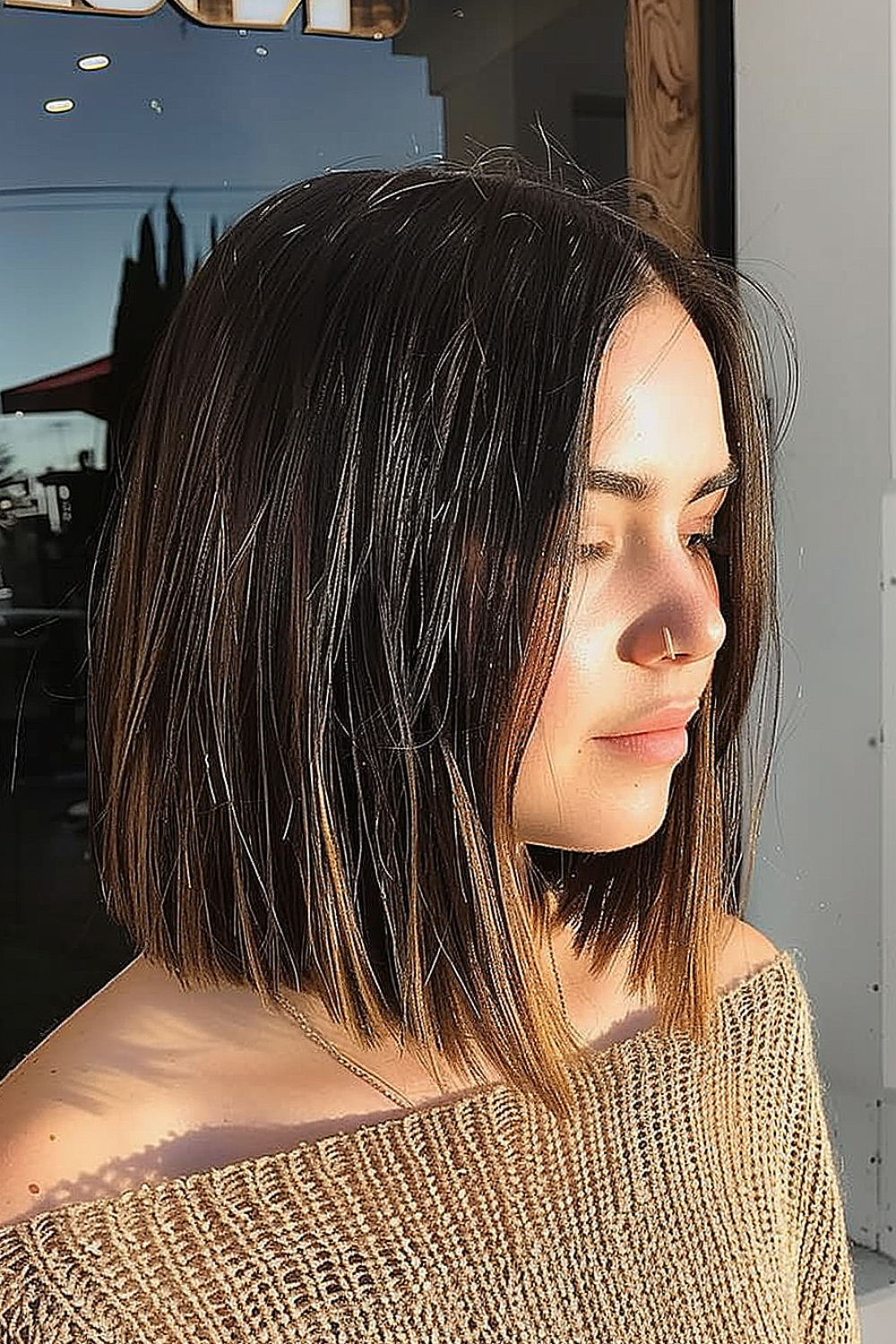 A soft blunt lob with natural texture and subtle sunlit highlights offering a relaxed, yet sophisticated style