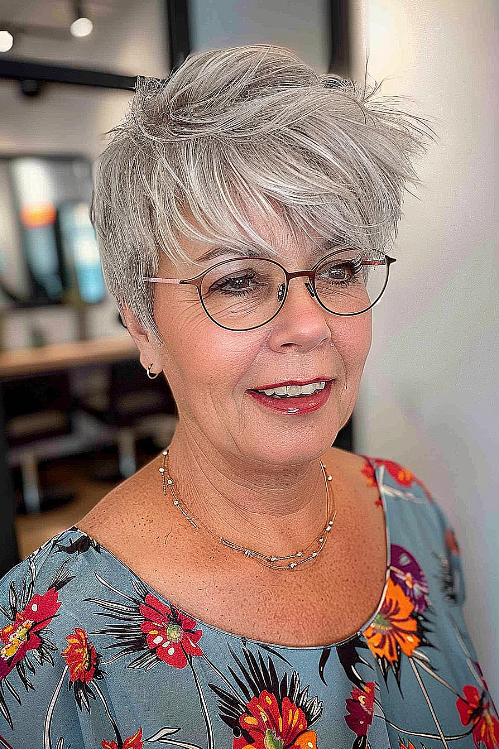 Woman with a soft layered pixie hairstyle and wispy bangs in silver tones