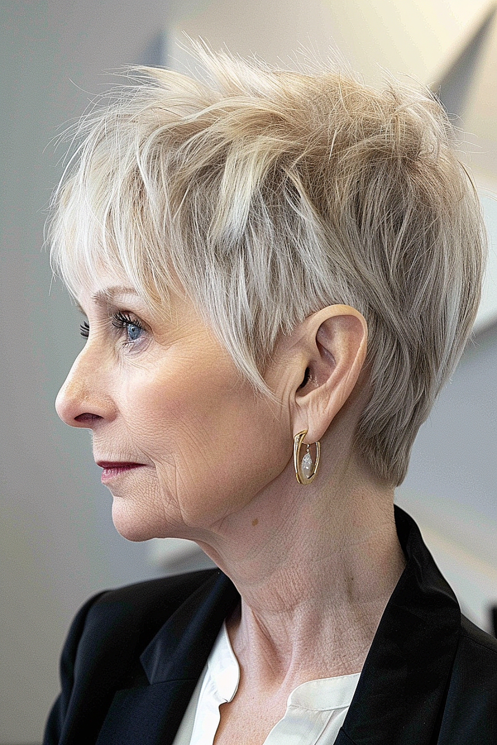 Sophisticated pixie cut with feathered layers and silver hues for women over 60