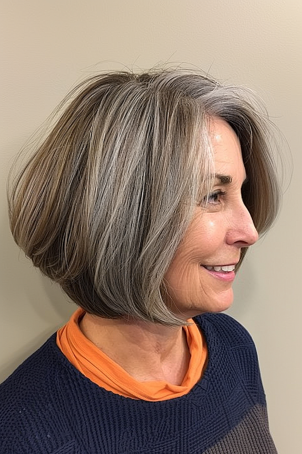 Smiling woman with a textured angled bob in silver and ash tones