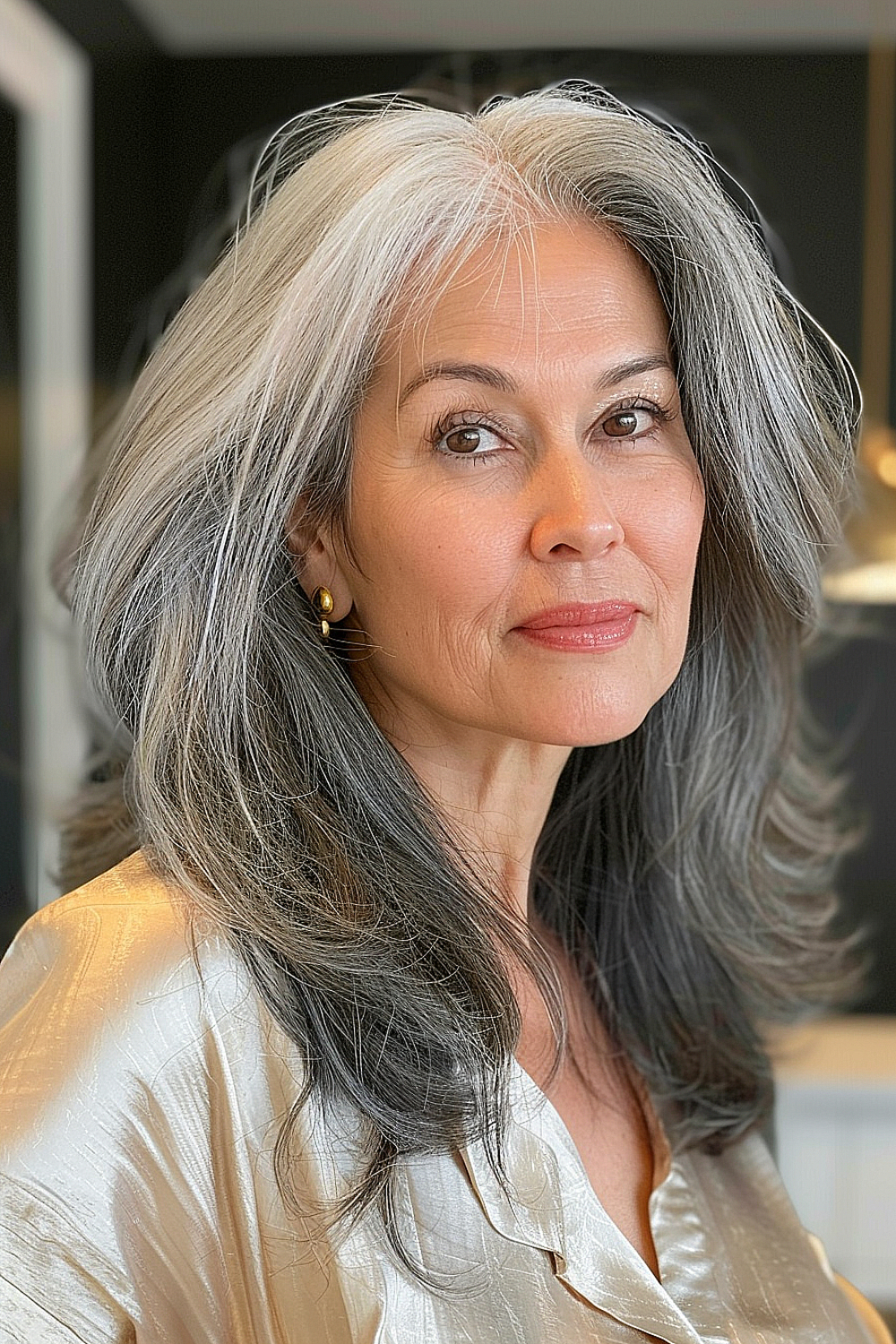 Woman over 50 with a timeless mid-length haircut, featuring a beautiful blend of natural grays and silvers