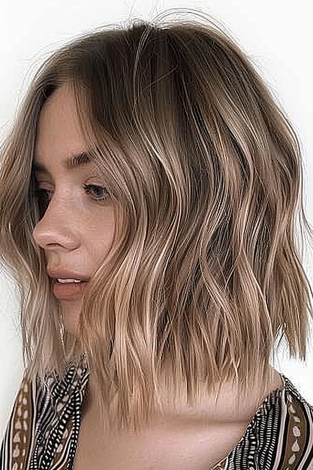 A tousled long bob with a smooth ombré transition from darker roots to lighter ends