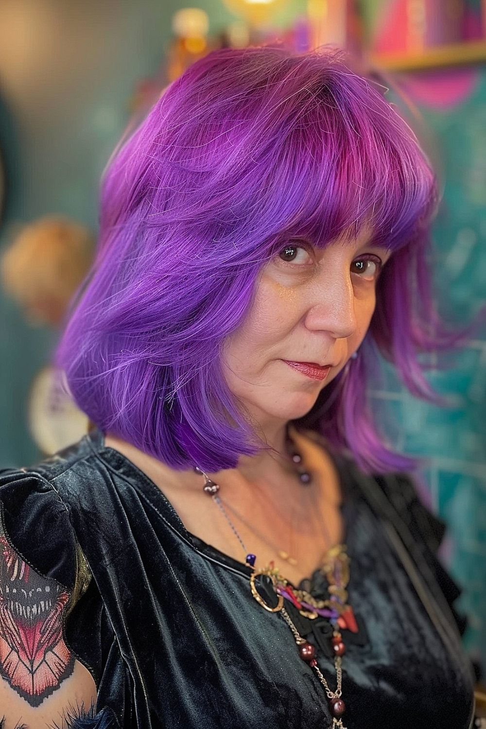 Woman with a vibrant violet lob and feathered bangs