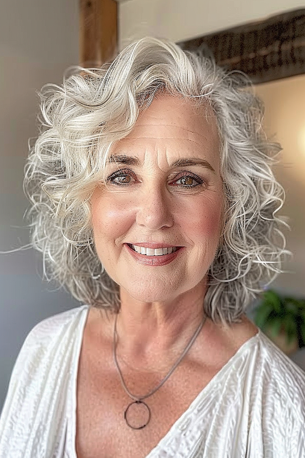 A woman with a luminous wavy lob, adorned with gentle curls, highlighting her silver hair