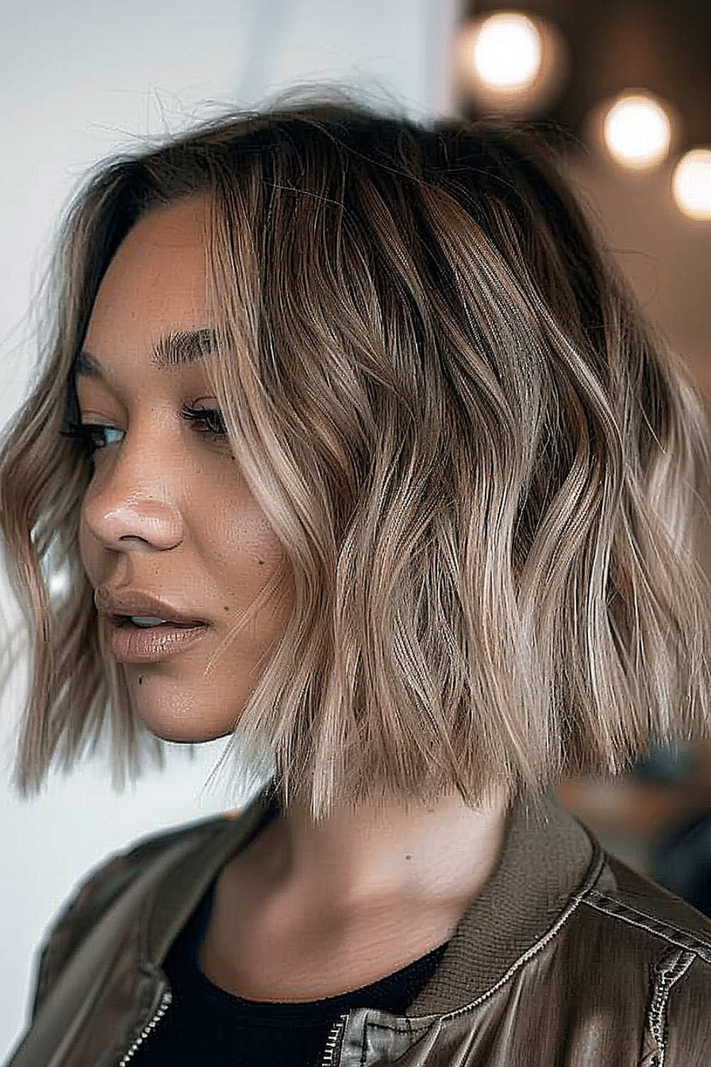 Woman with a wavy textured bob and ombre hair color.