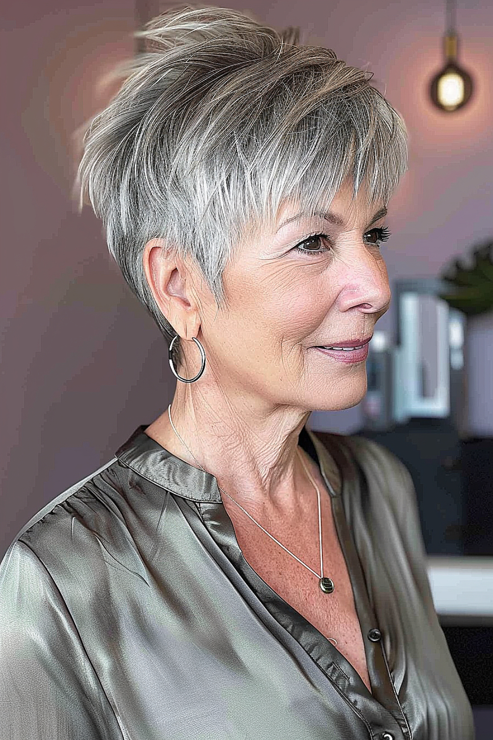 Mature woman with a wispy layered pixie haircut, featuring natural gray blending